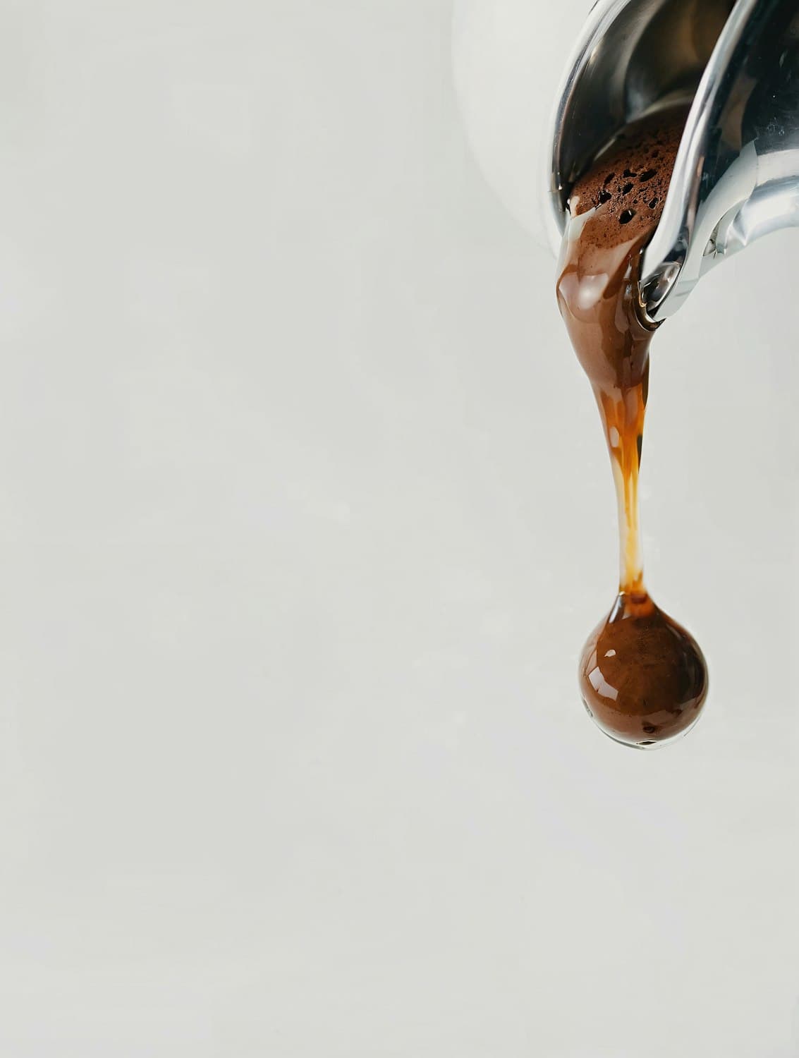 Espresso cayendo del pico de la cafetera
