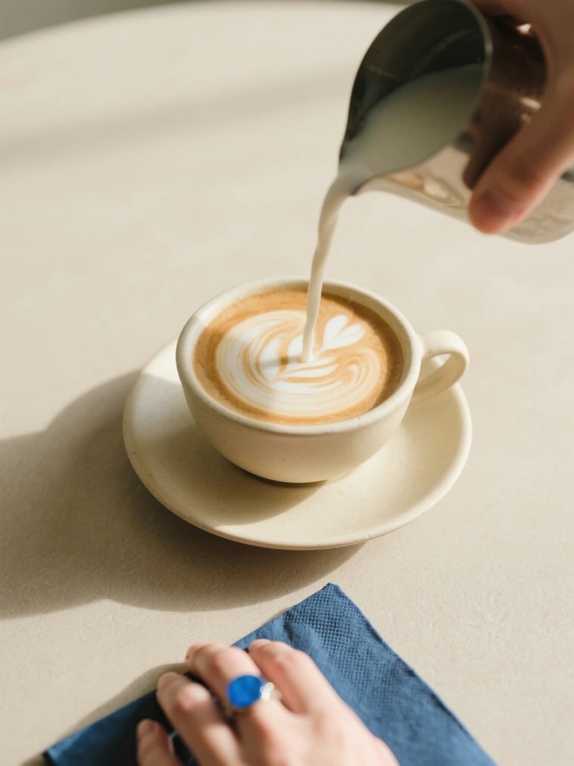 Leche texturizada cayendo sobre un café con latte art