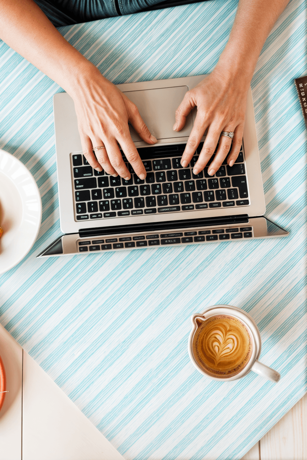 Café con latte art junto a una computadora sobre la mesa